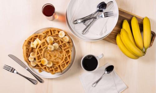 a table topped with a plate of waffles and bananas at Drury Plaza Hotel Nashville Downtown in Nashville
