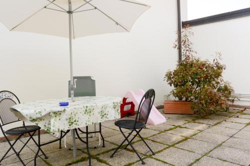 a table with chairs and an umbrella on a patio at Albergo Meublè Abatjour in Mantova
