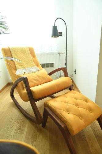 a rocking chair and a foot stool in a room at Apartman Milja in Požega
