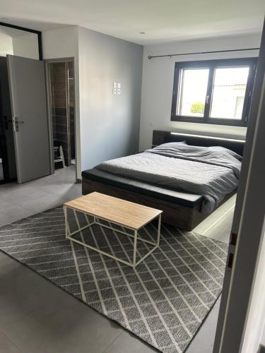 - une chambre avec un lit et une table basse dans l'établissement grande villa avec piscine, à Bompas