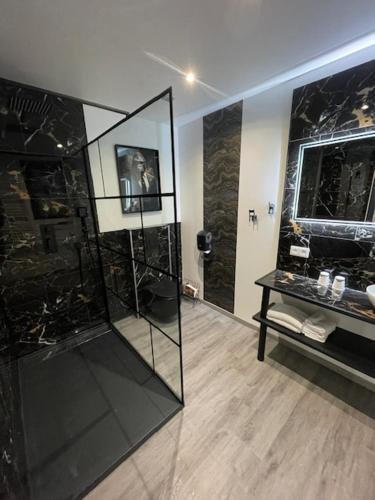 a bathroom with a glass shower and a table at studio269 in Flers