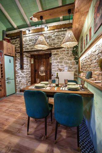 a dining room with a wooden table and blue chairs at Archontiko Theofanous in Tríkala