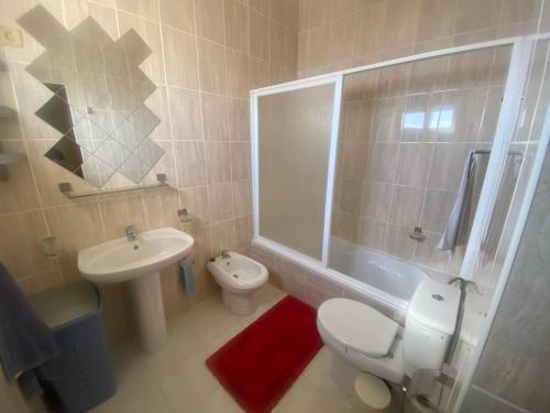 a bathroom with a white toilet and a sink at Casa Ramanda in Tarrafal
