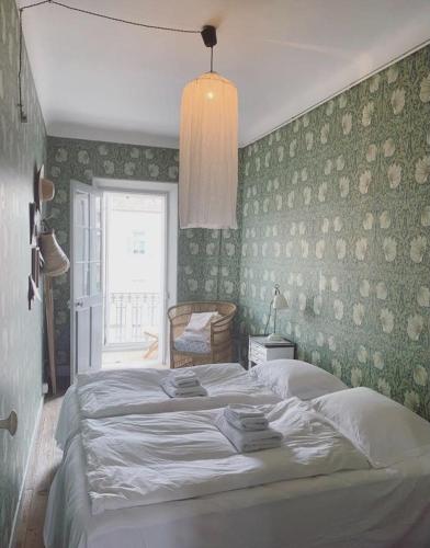 - une chambre avec un grand lit blanc et du papier peint vert dans l'établissement French classic apartm 2 bedroom best location, à Cannes