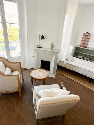 un salon avec deux chaises et une cheminée dans l'établissement French classic apartm 2 bedroom best location, à Cannes
