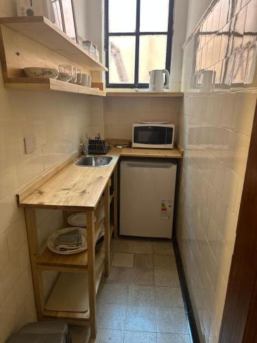 a small kitchen with a sink and a microwave at Hotel Hey U in Santa Fe