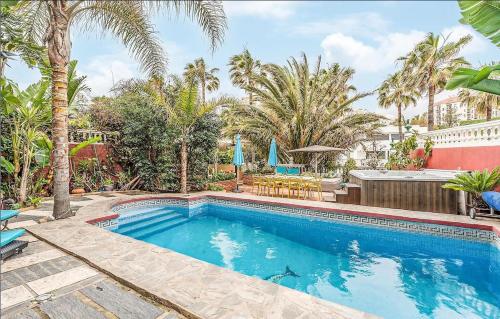 a swimming pool in a yard with palm trees at Majestic Villa by the Beach Heated Private Pool & Jacuzzi in Benalmádena