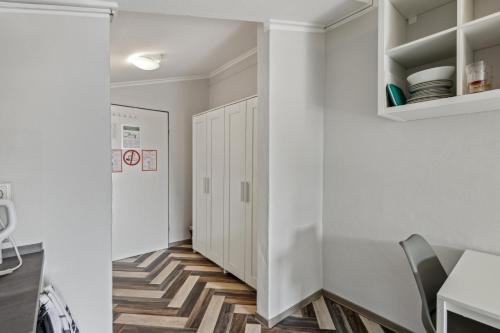 a hallway with white walls and a table and a chair at Sali Homes - Ferienwohnung in Kevelaer - Comfort in Kevelaer