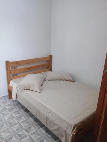 a bed with a wooden headboard in a bedroom at Pousada Amigu's in Pontal do Paraná