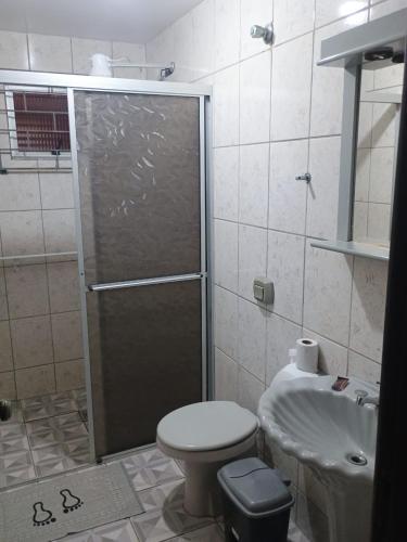 a bathroom with a shower and a toilet and a sink at Pousada Amigu's in Pontal do Paraná