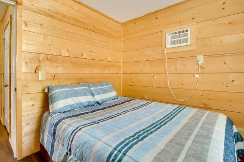 a bedroom with a bed in a wooden wall at Cabin Getaway in Mountain View with Porch and Grill in Mountain View