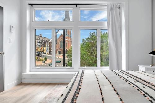 an empty white room with a large window at Urban Nest #3 Bright loft steps to Proctors in Schenectady