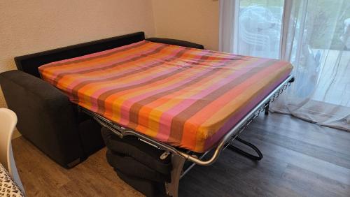- un lit avec une couverture colorée dans l'établissement Agréable et familiale T2 Canet Plage, à Canet