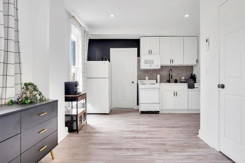 a kitchen with white cabinets and a white refrigerator at Urban Nest #4 Chic studio central to downtown in Schenectady