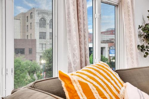 a couch sitting in front of a large window at Urban Nest #5 Modern apartment steps to Proctors in Schenectady