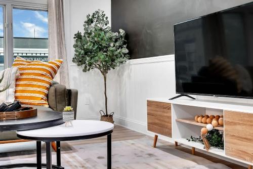 a living room with a flat screen tv on a cabinet at Urban Nest #5 Modern apartment steps to Proctors in Schenectady