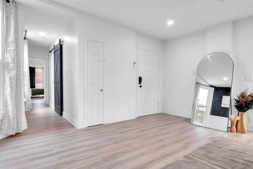 an empty room with white walls and a mirror at Urban Nest #5 Modern apartment steps to Proctors in Schenectady