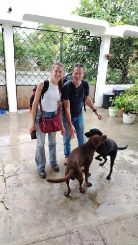 a man and a woman standing next to a dog at Caracola, habitación privada de Flor de Lis Beach House in Playas