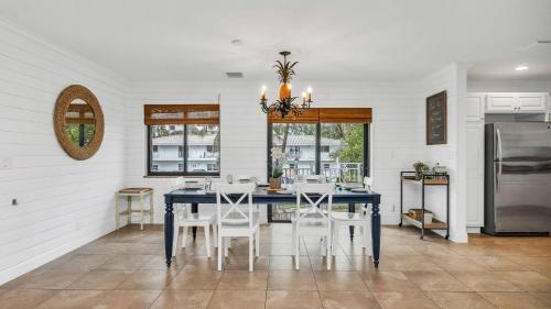 a dining room with a blue table and white chairs at Designer Beachside Serenity Steps to the Beach! in Juno Beach
