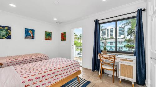 a bedroom with a bed and a desk and a window at Designer Beachside Serenity Steps to the Beach! in Juno Beach