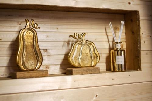 three gold bottles on a shelf with a bottle of perfume at Archontiko Theofanous in Tríkala