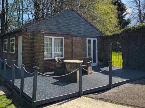 une terrasse en bois avec une table et des chaises dessus dans l'établissement Grandwood House Lodges, à Chichester