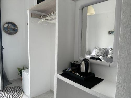 a room with white walls and a mirror at Calypso Heaven in Santorini