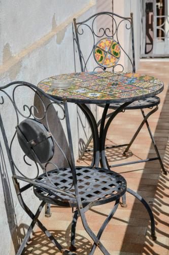 a wrought iron table and chair sitting on a porch at Le Sciosce in San Giorgio Lucano