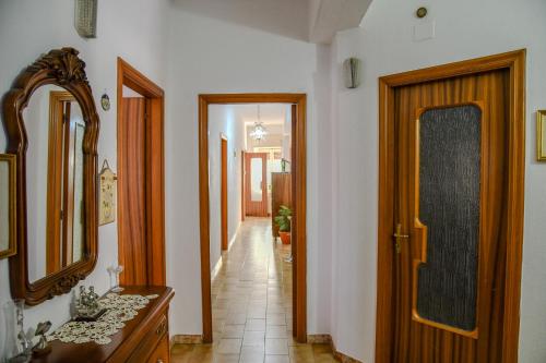 a hallway with a mirror and a wooden door at Le Sciosce in San Giorgio Lucano