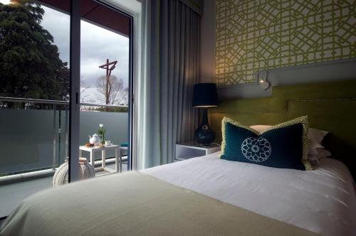 a bedroom with a bed and a large window at Coração de Fatima Boutique Hotel in Fátima