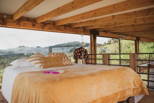 a bedroom with a large bed in a room with windows at Chocó 701 La Reserva- Casa Loft in Culantropamba