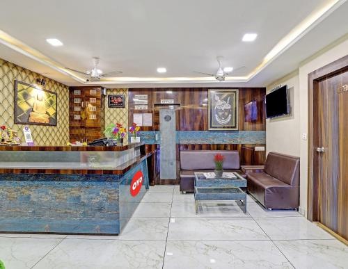 a hotel lobby with a bar and leather chairs at Collection O Hotel Raj Palace in Vadodara