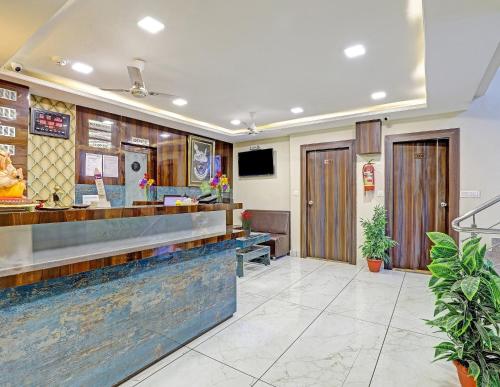 a restaurant with a counter and a lobby at Collection O Hotel Raj Palace in Vadodara