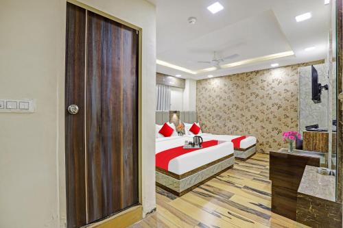 a bedroom with a bed with a woman sitting on it at Collection O Hotel Raj Palace in Vadodara
