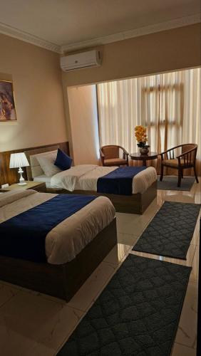 a hotel room with two beds and a table at VIP Hotel Amman in Amman