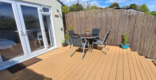 a patio with a table and chairs and a fence at The Snug - for Eurotunnel, North Downs Way & Golfing in Folkestone