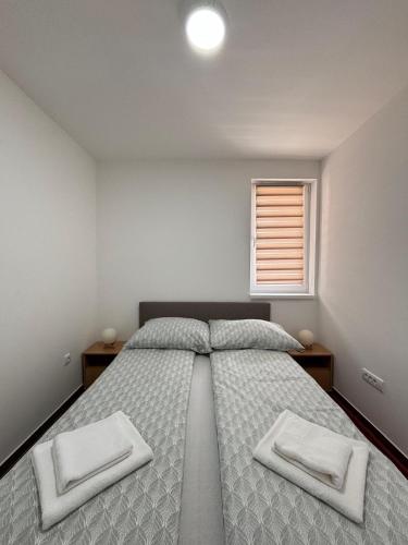 a bedroom with a large bed with two white towels at Šojmesković in Veliko Gradište