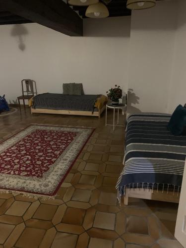 - une chambre avec 2 lits, une table et un tapis dans l'établissement Maison entière Ibra, à Saint-Agil