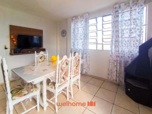 a dining room with a white table and chairs at Cobertura com Vista e Conforto no RS in Santo Ângelo