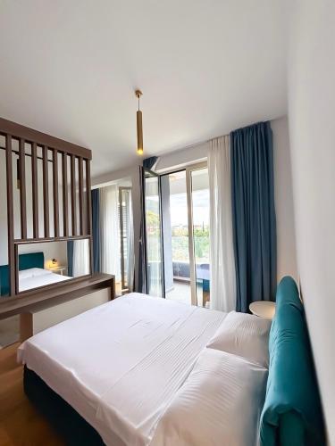 a bedroom with a large white bed and a window at Luxe Beachfront Stay in Bečići with Pool in Budva