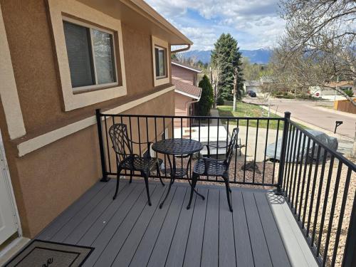 a patio with a table and chairs on a balcony at Purple Mountain Majestic Retreat in Colorado Springs