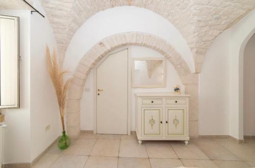 a hallway with an archway and a white door at Palazzo Lama in Martina Franca