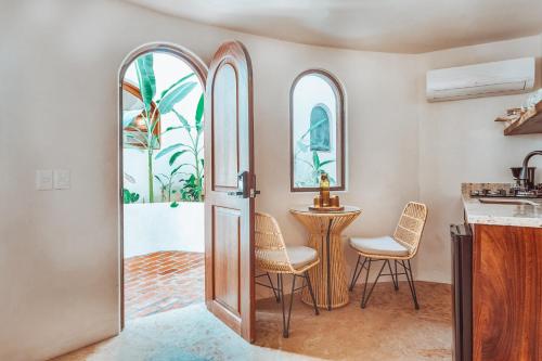 a kitchen with a table and chairs next to a door at Amari Sayulita Boutique Hotel in Sayulita