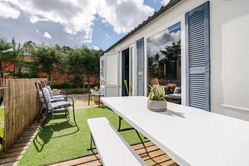 a patio with a white table and chairs at 1A Casa Azul in Pataias