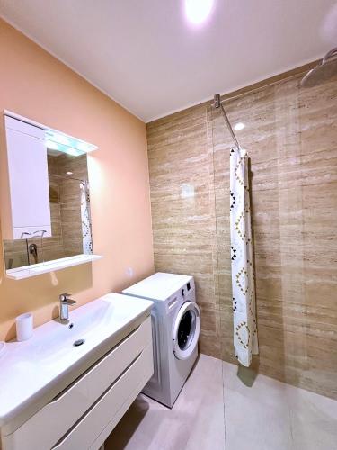 a bathroom with a washing machine and a sink at Luxe Beachfront Stay in Bečići with Pool in Budva