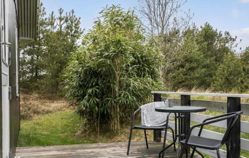 BolilmarkにあるHoliday Home Romo With Sauna 331のデッキにテーブルと椅子が置かれたパティオ