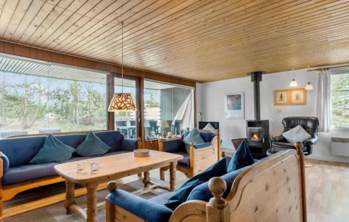 BolilmarkにあるHoliday Home Romo With Sauna 331の青いソファと木製の天井が備わるリビングルーム