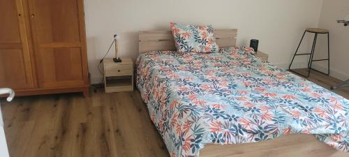 une chambre avec un lit avec une couette colorée dans l'établissement L'Agapanthe, Gîte au coeur de la Baie de Saint Brieuc, à Hillion