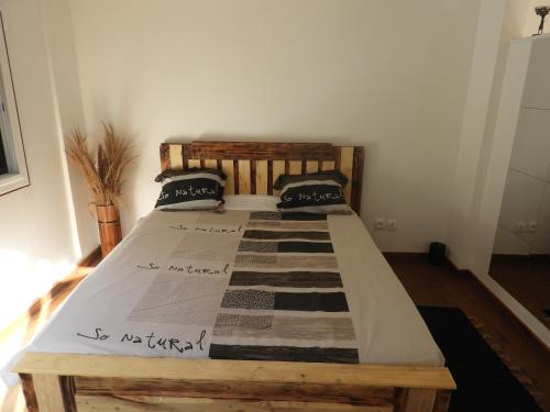 Un dormitorio con una cama de madera en una habitación. en Cocon Siloé, en Petit-Bourg