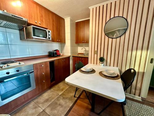 a small kitchen with a white table and a mirror at Santiago Urbano Apartments - Centric Santiago in Santiago